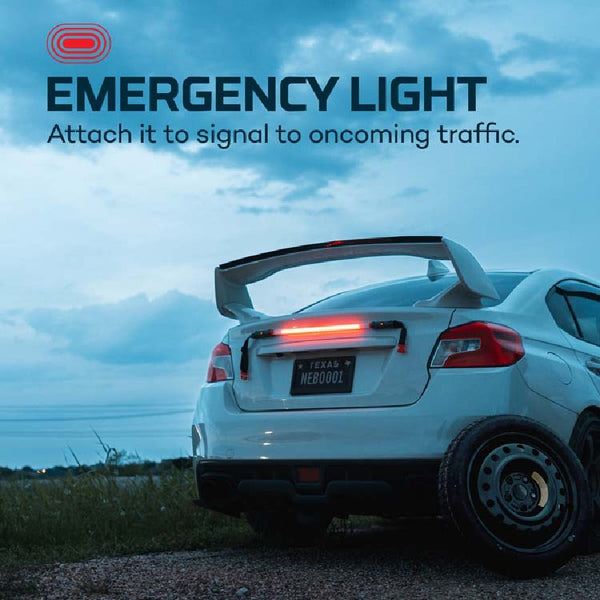 White car with the Nebo Bando 1k work light attached to the back as an emergency light, set against a blue sky.