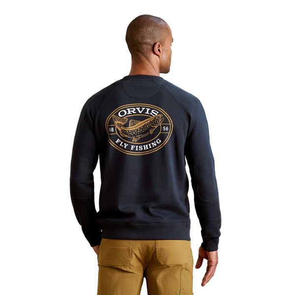 Man wearing khaki pants and the navy blue Orvis Men's Campfire Crewneck Pullover Sweatshirt with a trout graphic on the back, against a white background.