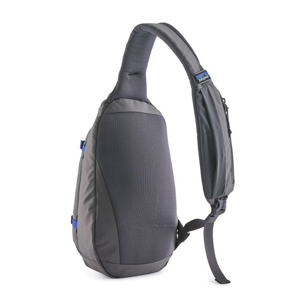 A may grey Patagonia Atom Sling 8L with adjustable shoulder strap and multiple compartments, designed for close-fitting comfort shown from the back on a white background.