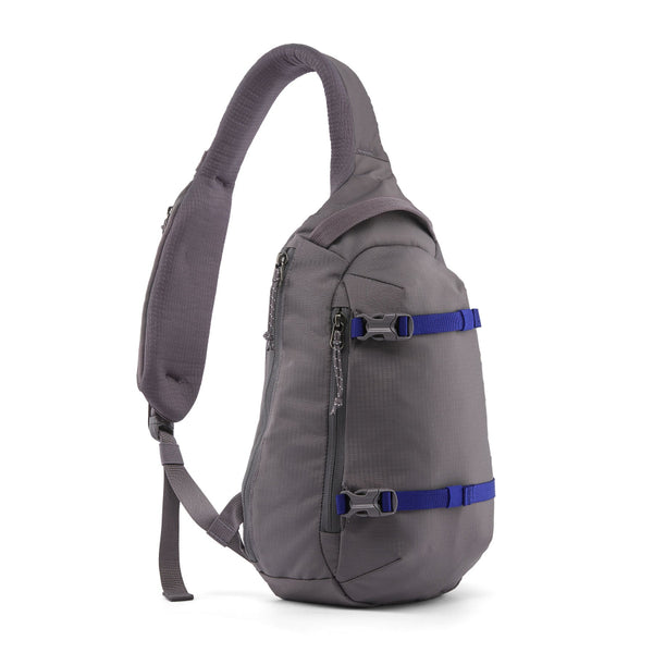 A may grey Patagonia Atom Sling 8L with adjustable shoulder strap and multiple compartments, designed for close-fitting comfort on a white background.