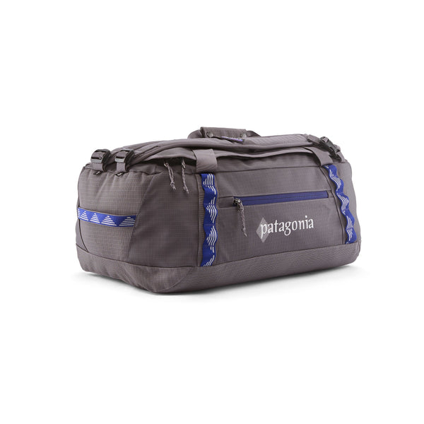 A Hut Tripper: May Grey 40-Liter Patagonia Black Hole Duffel Bag showing side logo and pocket with blue accents, on a white background.