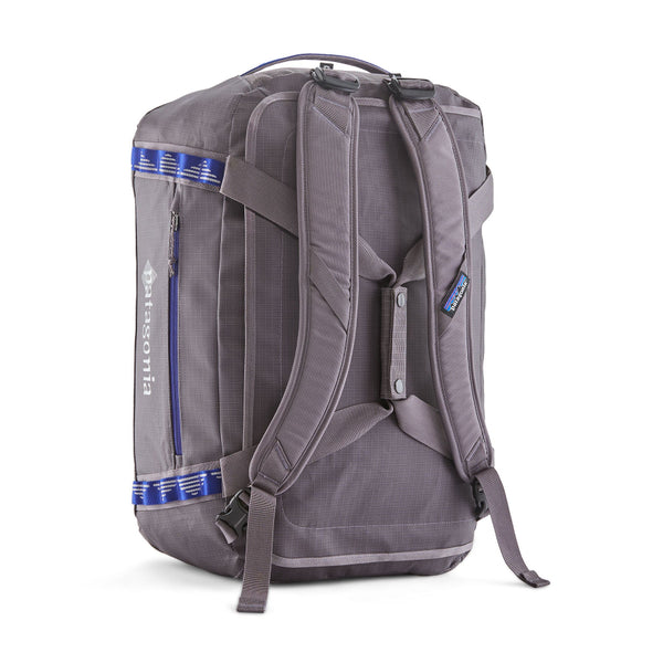 A Hut Tripper: May Grey 40-Liter Patagonia Black Hole Duffel Bag showing the backpack straps attached and the side logo and pocket with blue accents, on a white background.