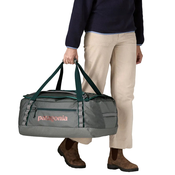 Person holding a noble grey 55-Liter Patagonia Black Hole Duffel Bag against a white background.