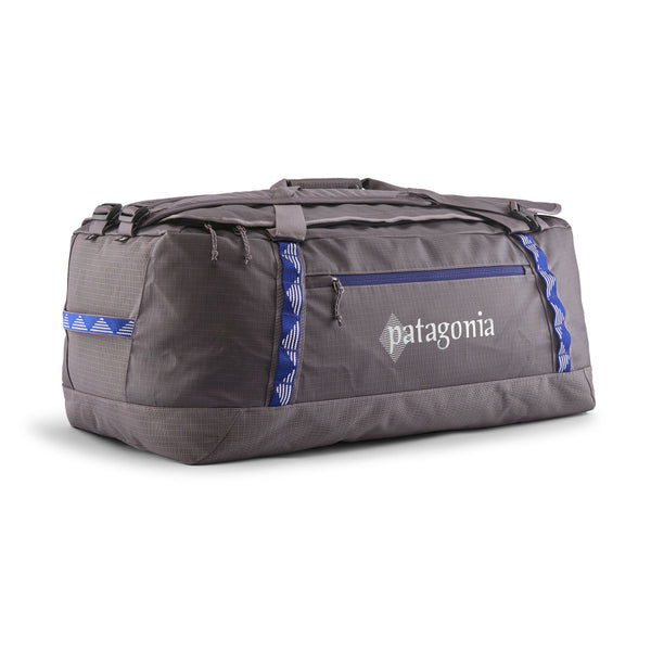 Hut Tripper: May Grey 70-Liter Patagonia Black Hole Duffel Bag showing side logo and pocket with blue details, on a white background.