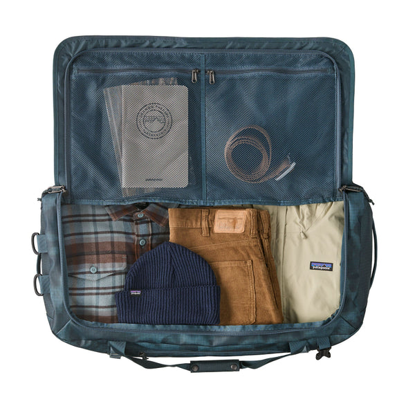 Open and packed sastrugi summit blue 70-Liter Patagonia Black Hole Duffel Bag demonstrating how clothing and accessories (not included) fit inside the interior, on a white background.