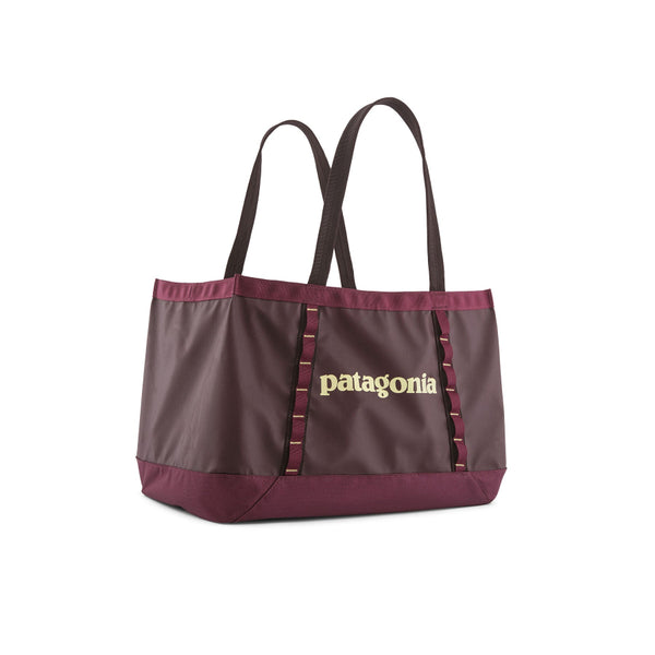 The 25-liter Patagonia Black Hole Gear Tote in berry fig with a light yellow logo on the side, on a white background.