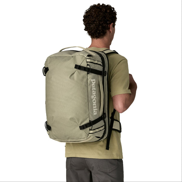 Person wearing a weathered stone Patagonia Black Hole MLC Briefcase Backpack 45L on a white background.