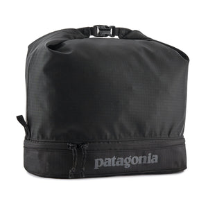 A black Patagonia Black Hole MLC Cube 12L with a roll-top design and a separate zippered compartment, on a white background.