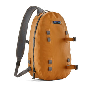 Patagonia Guidewater Waterproof Fishing Sling Pack in golden caramel color designed for carrying fishing equipment, on a white background.