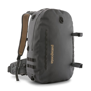 Forge grey 25-Liter Patagonia Guidewater Waterproof Backpack showing front with tan Patagonia logo and removable gear straps on a white background.