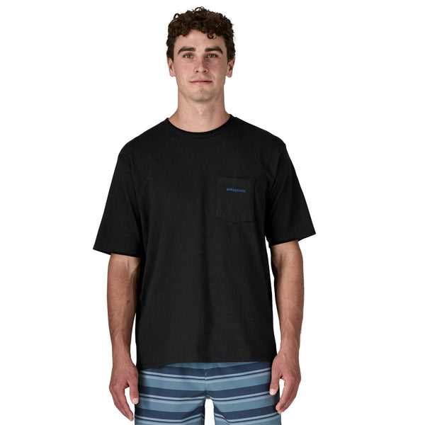 Person wearing a black Patagonia Boardshorts Logo t-shirt with a pocket on the front, standing against a white background.