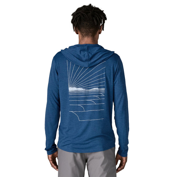 Man wearing a clement blue Patagonia Men's Cap Cool Daily Hoody with waves rolling graphic on the back, on a white background.