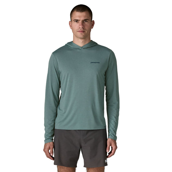 Person wearing black shorts and the blue sage color Patagonia Men's Capilene Cool Daily Hoody, against a white background.
