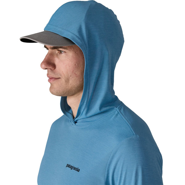 Person wearing the shore blue x-dye Patagonia Men's Capilene Cool Daily Hoody Casting Logo showing hood details from the side against a white background.