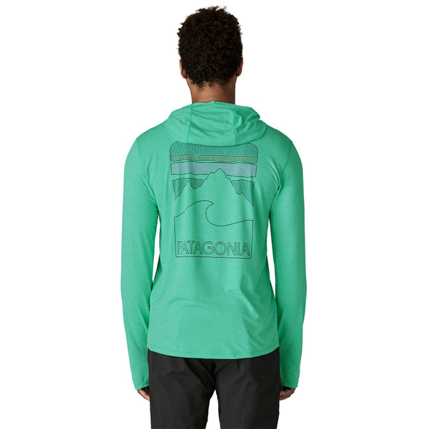 Person wearing the aqua stone and teal x-dye color  Patagonia Men's Capilene Cool Sun Hoody with Peak Visions graphic on the back, on a white background.