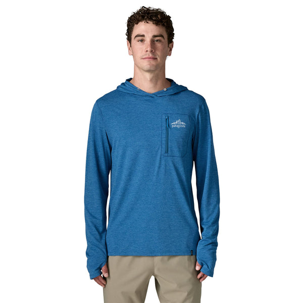 Front view of  a person wearing the aquatic blue Patagonia Men's Capilene Cool Sun Hoody with the cloud crag crest on the zipper pocket front right chest and khaki pants, on a white background.