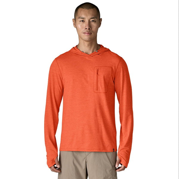 Person wearing a coal orange x-dye Patagonia Men's Capilene Cool Sun Hoody and khaki pants against a white background.