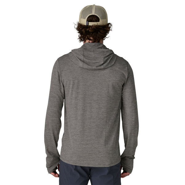 Person wearing blue pants and a noble grey x-dye Patagonia Men's Capilene Cool Sun Hoody shown from the back against a white background.