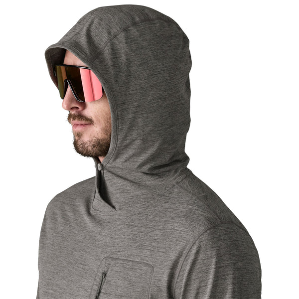 Person wearing mirrored sunglasses and a noble grey x-dye Patagonia Men's Capilene Cool Sun Hoody, showing hood and neck details, against a white background.