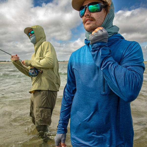 Two people fly fishing on saltwater flats, one in a blue Patagonia Capilene Cool Sun Hoody and the other in a green Patagonia Capilene Cool Sun Hoody.