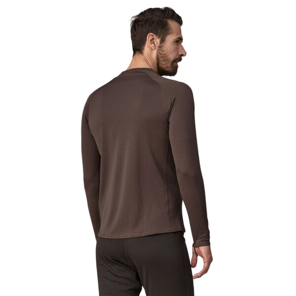 Person wearing a Patagonia Men's Capilene Midweight Crew in brown color featuring long sleeves and a round neckline, on a white background.