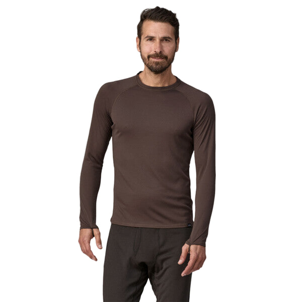 Person wearing a Patagonia Men's Capilene Midweight Crew in brown color featuring long sleeves and a round neckline, on a white background.
