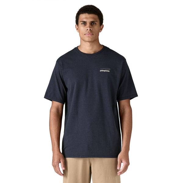 Person shown from the front wearing tan pants and the Patagonia Men's Casting Logo Responsibili-Tee in Smolder Blue against a white background.