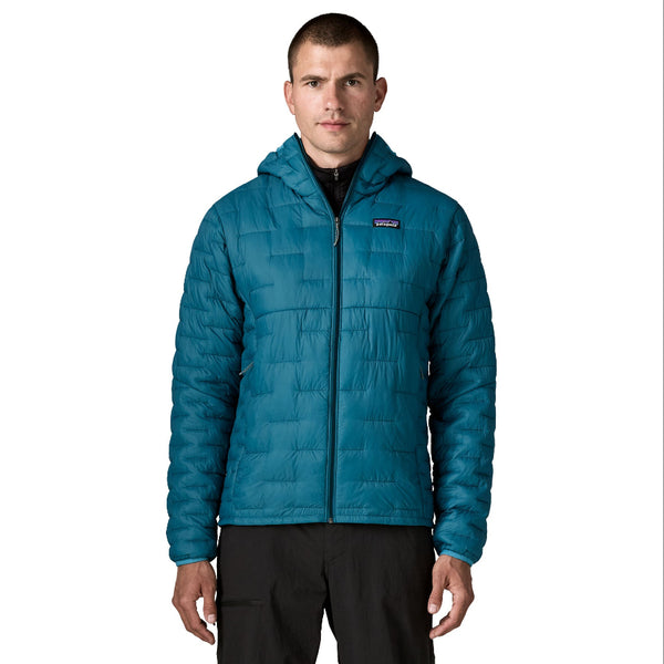 A person shown from the front wearing black pants and the Glacial Blue Patagonia Men's Micro Puff Insulated Hoody on a white background.