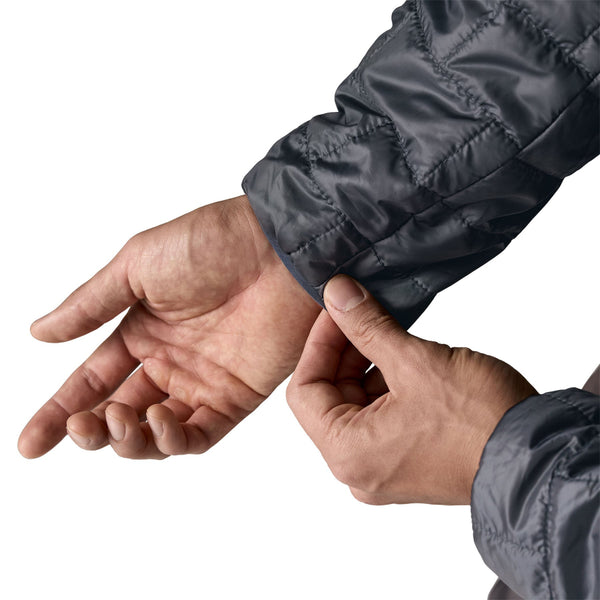 Person wearing a smolder blue Patagonia Men's Nano Puff Insulated Hoody, showing the cuff details close up, against a white background.