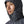 Person a smolder blue Patagonia Men's Nano Puff Insulated Hoody, showing the hood details fully zipped up in close up, against a white background.