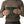Person holding the old growth green Patagonia Men's Nano Puff quilted vest stuffed into it's own pocket, on a white background.