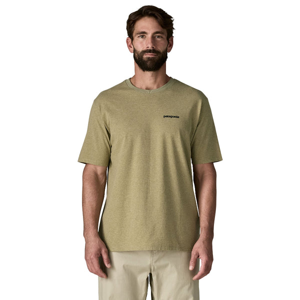 Man wearing a gumtree green Patagonia P-6 Logo t-shirt with khaki pants, against a white background.