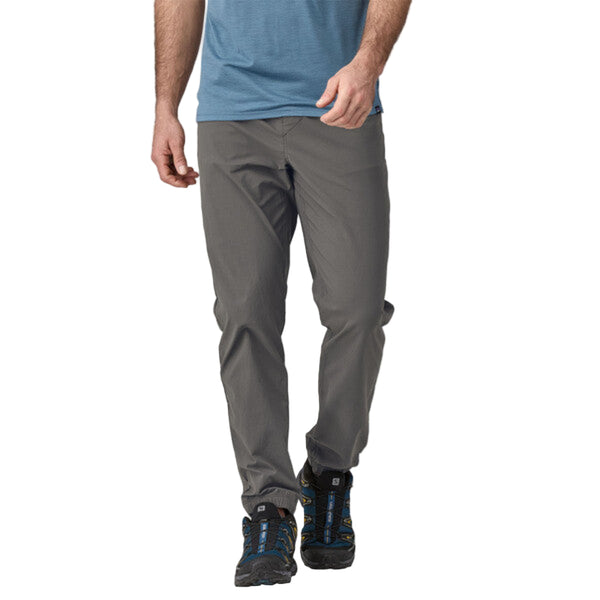 Person wearing Patagonia Men's Quandary Joggers in grey, featuring multiple pockets and a drawcord waistband on a white background.