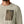 Close-up of front pocket on a beige Patagonia R1 Air Fleece textured shirt with a Patagonia logo on a white background.