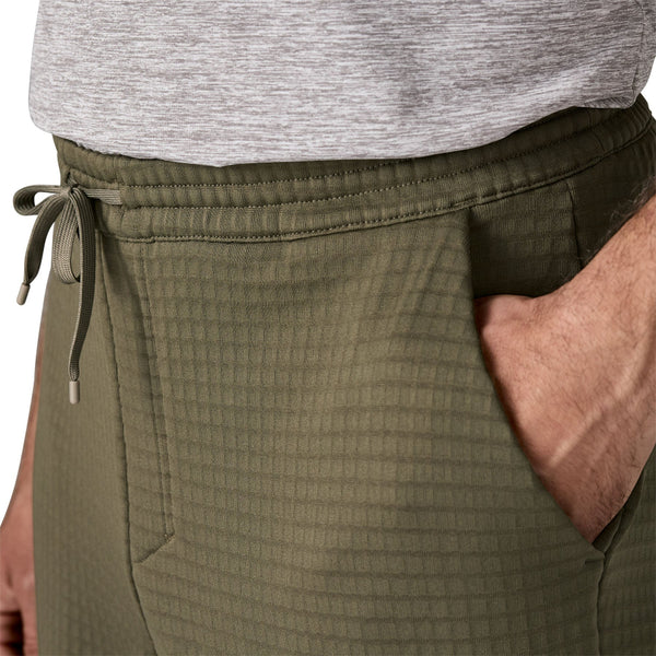 Close up of the waistband and pocket details on the basin green Patagonia Men's R1 Fleece Pants, on a white background.
