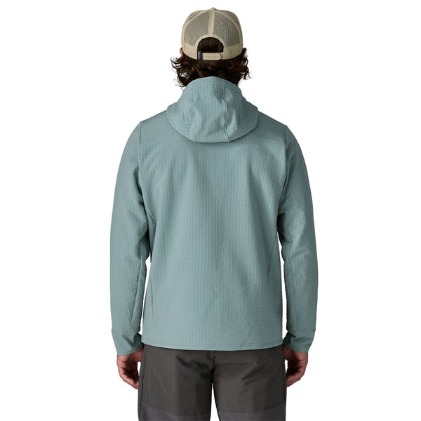 Man wearing grey pants and the blue sage hooded Patagonia Men's R2 Techface Pullover on a white background.