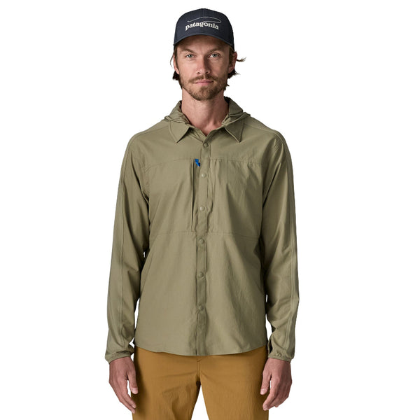 Person wearing brown pants and a men's Patagonia River Rambler Hybrid UPF Sun Hoody in River Rock Green, featuring a collar and button front on a long sleeved shirt, with a removable hood, against a white background.