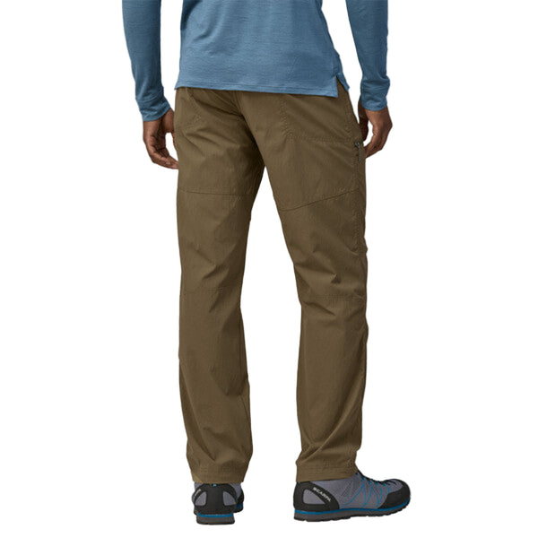 Person wearing Patagonia Men's RPS Rock Pants in dark ash, featuring multiple pockets and a flexible, articulated design on a white background.