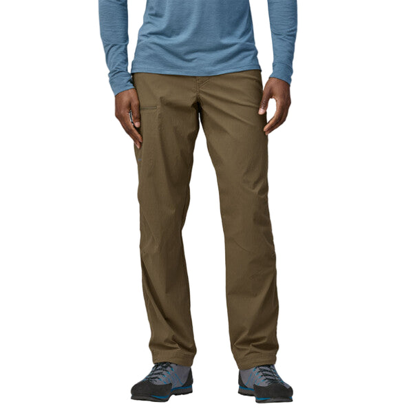 Person wearing Patagonia Men's RPS Rock Pants in dark ash, featuring multiple pockets and a flexible, articulated design on a white background.
