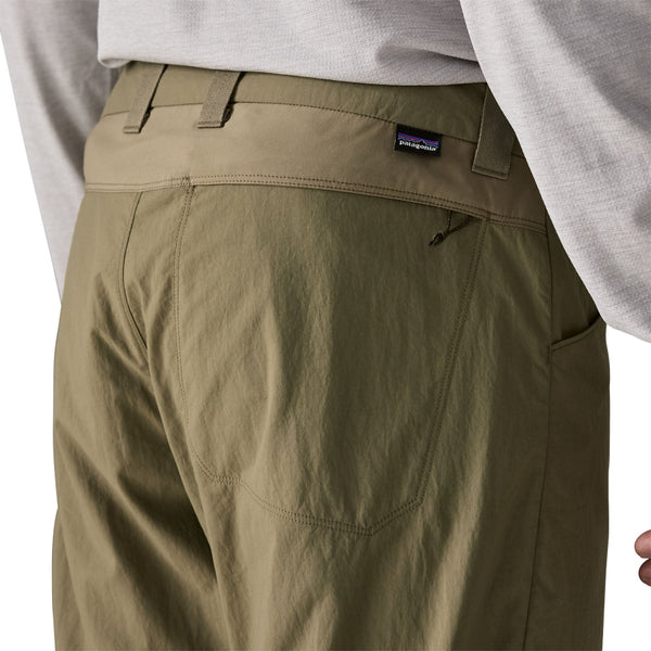 Person wearing sage khaki  Patagonia Men's Sandy Cay Wading Pants showing back pocket details on a white background.