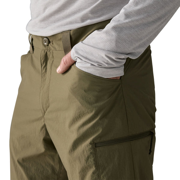 Person wearing sage khaki  Patagonia Men's Sandy Cay Wading Pants showing side pocket details on a white background.