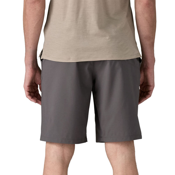 Person wearing forge grey Patagonia Men's Terrebonne Shorts and a beige top on a white background.