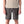 Person wearing forge grey Patagonia Men's Terrebonne Shorts and a beige top on a white background.