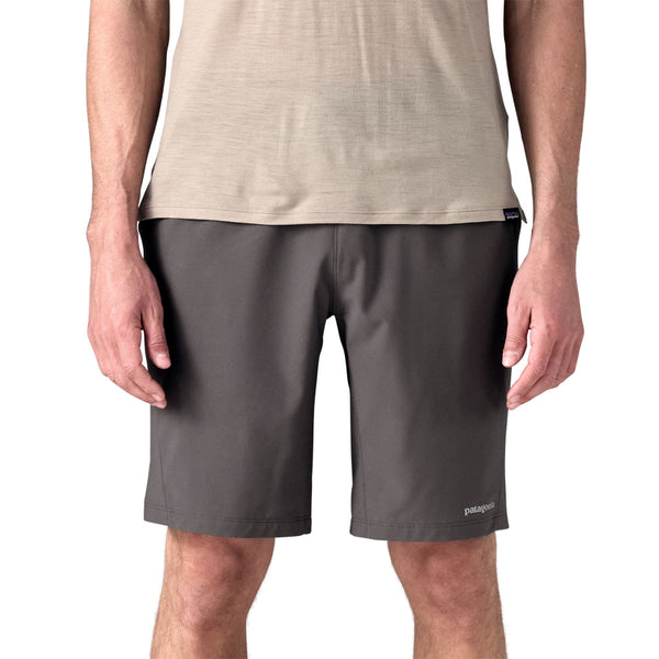 Person wearing forge grey Patagonia Men's Terrebonne Shorts and a beige top on a white background.
