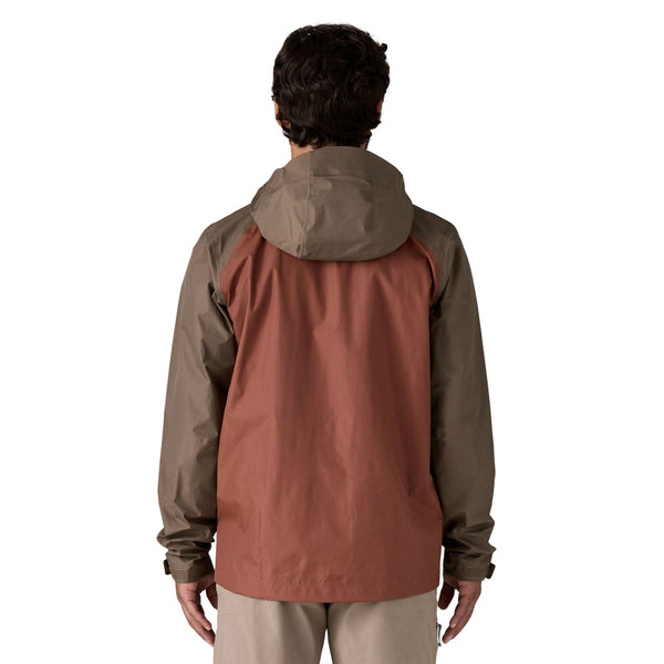Person wearing a Patagonia Men's Torrentshell 3L Rain Jacket in Marlow Brown and tan pants on a white background.