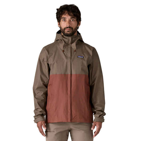 Person wearing a Patagonia Men's Torrentshell 3L Rain Jacket in Marlow Brown and tan pants on a white background.