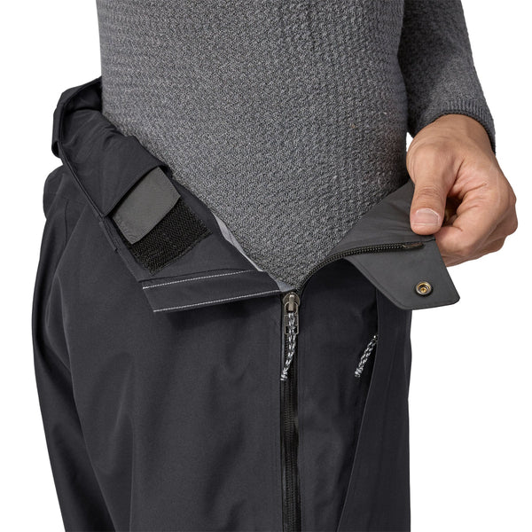 Person wearing black Patagonia Men's Triolet Alpine Pant showing the waist zipper detail on a white background.