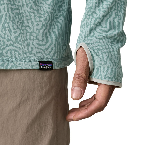 Person wearing khakis and the sea run - sage blue color Patagonia Men's Tropic Comfort Natural Sun Hoody on a white background.
