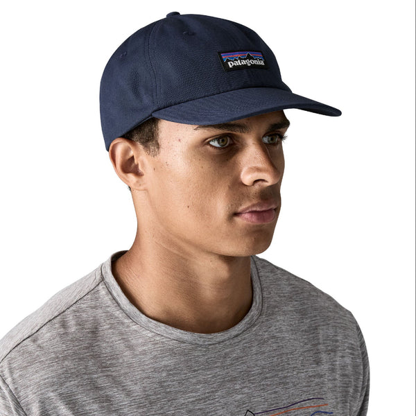 Person wearing a grey t-shirt and a new navy color full cloth Patagonia P-6 Label Trad Cap, on a white background.