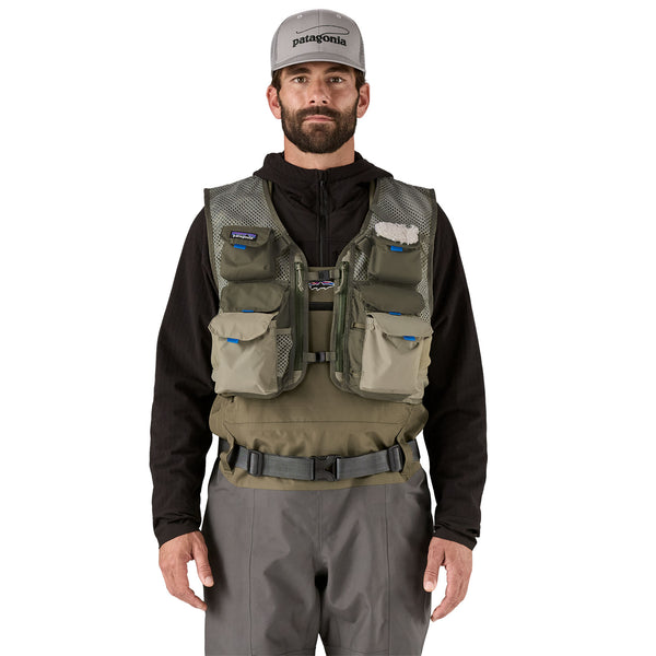 Person wearing fishing waders and the river rock green Patagonia Stealth Pack Fishing Vest with multiple pockets on a white background.